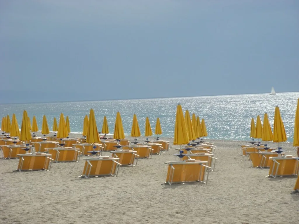 Rows of yellow umbrellas and loungers on Versilia sparkling shoreline