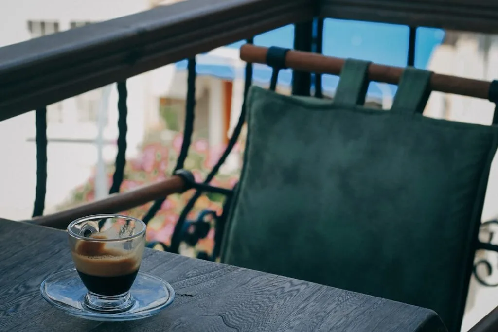 Small espresso cup on a wooden table at a Lucca balcony cafe