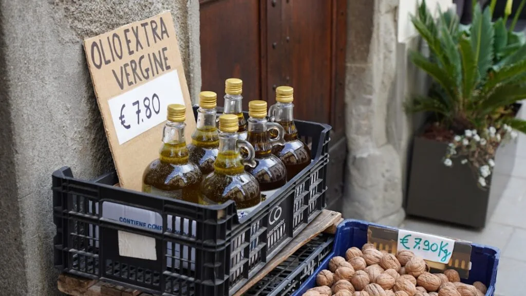 Crates of extra virgin olive oil bottles and walnuts for sale in Lucca