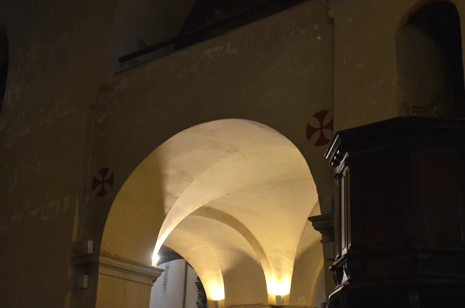 Dimly lit vaulted arches and wooden pulpit inside a Lucca church interior