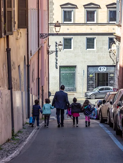 Man and children walking down narrow Lucca street holding hands