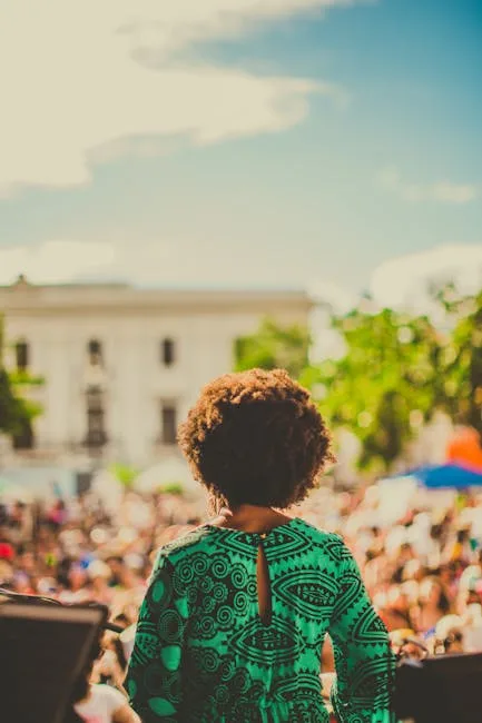 Person on stage facing a crowded outdoor audience in Lucca