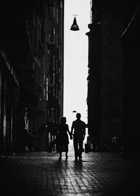 Silhouetted couple holding hands in a narrow Lucca alleyway
