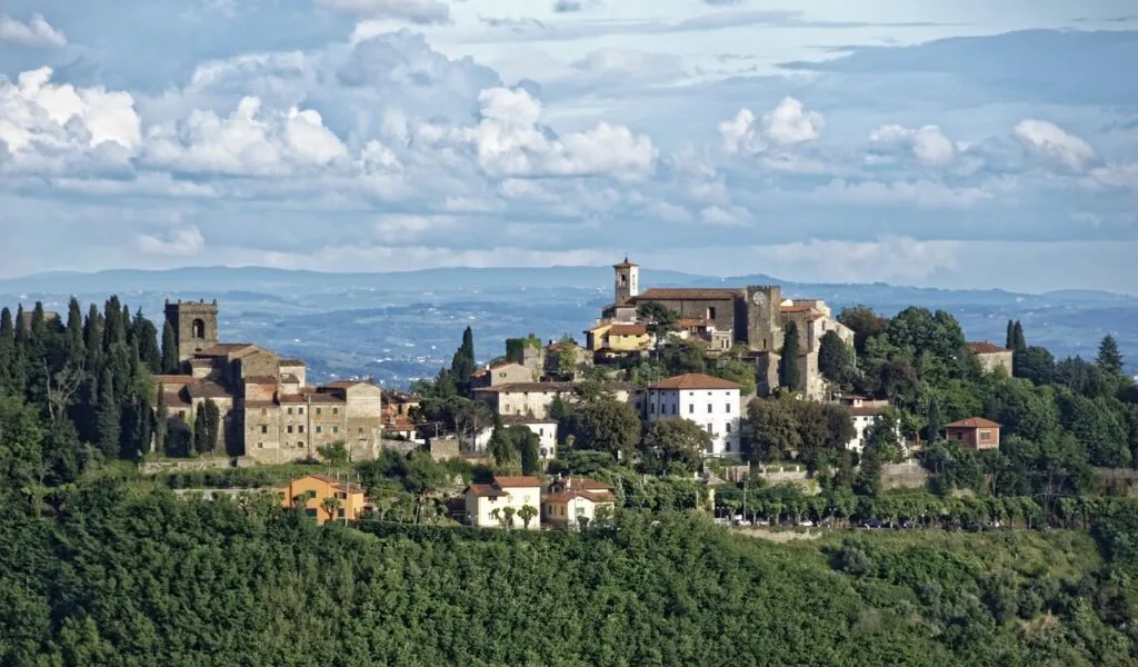 Hilltop Tuscan village surrounded by cypress trees and rolling hills near Lucca