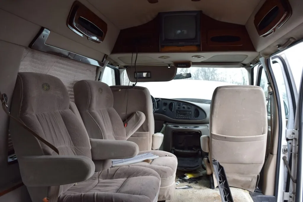 Worn shuttle van interior with plush seats for Lucca transfers