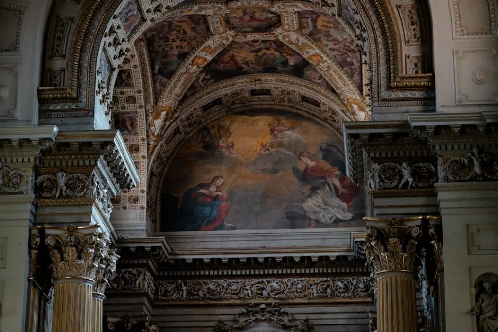 Ornate frescoed apse with Annunciation scene inside Lucca church