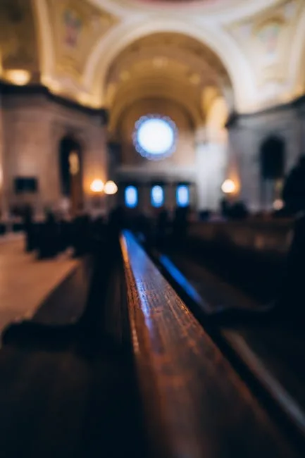Close-up of wooden pew with blurred Lucca church interior