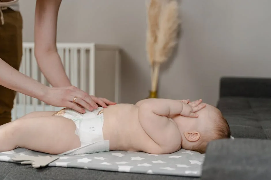 Baby lying on a changing mat while adult adjusts diaper in home setting