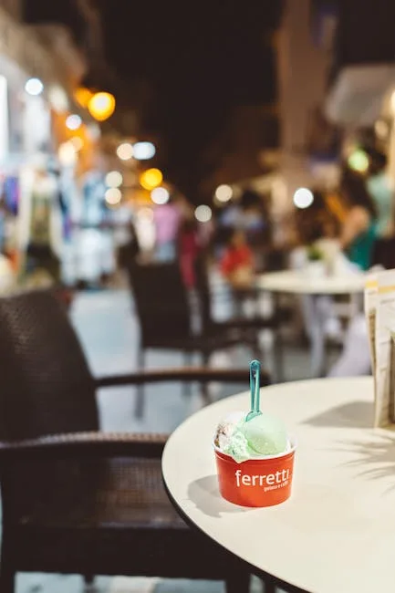Cup of gelato on café table with Lucca evening street bokeh