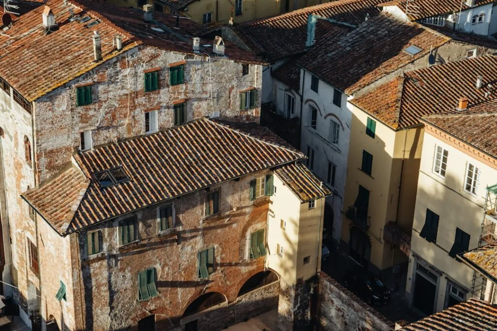 Aerial view of weathered terracotta rooftops and narrow alleys in Lucca
