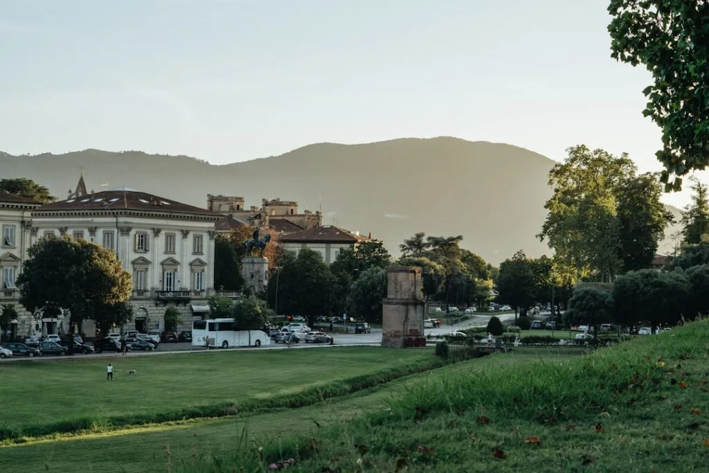 Lucca's grassy ramparts with mountains and historic buildings