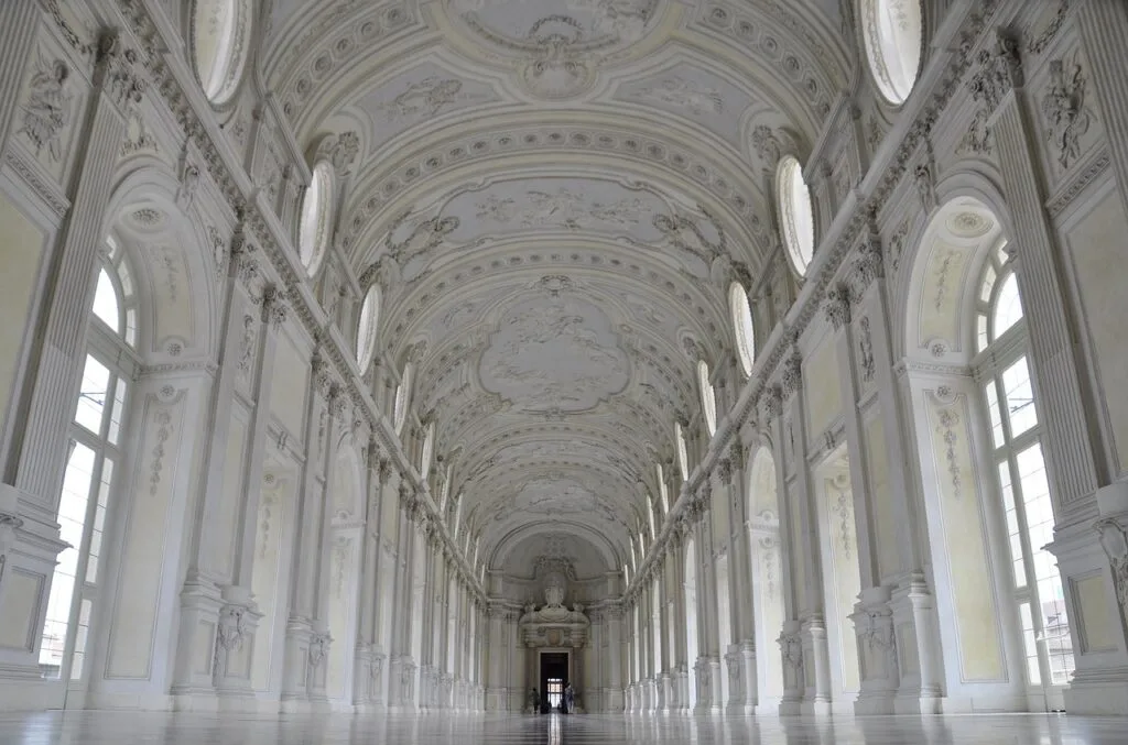 Ornate white vaulted gallery inside a Lucca historic palace.