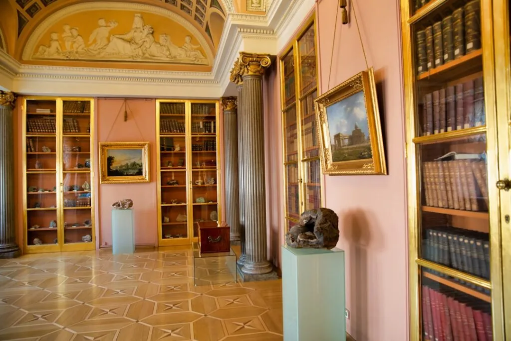 Elegant Lucca museum room with columns, glass bookcases and framed paintings