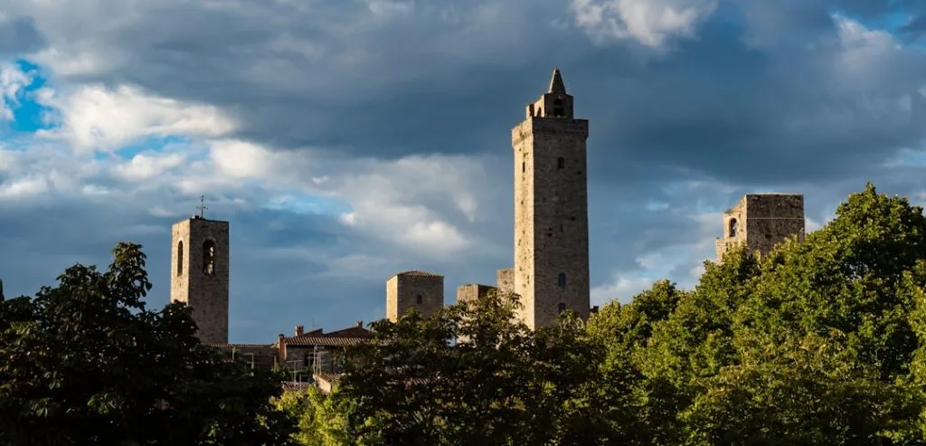 Tall medieval towers rising above trees in San Gimignano skyline