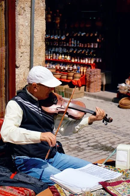 Street violinist playing outside a market stall in Lucca