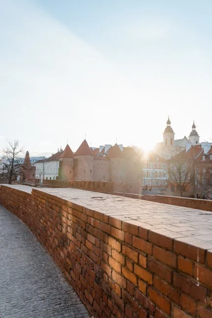 Sunrise behind historic red-brick bridge and distant church towers