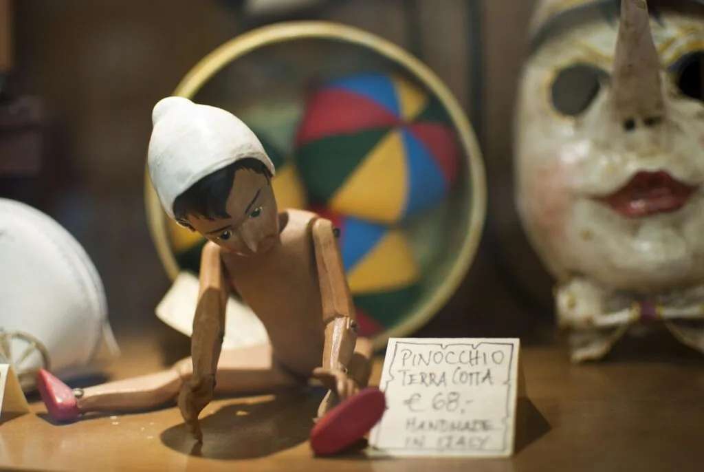 Close-up of small Pinocchio figure wearing white cap in Collodi shop