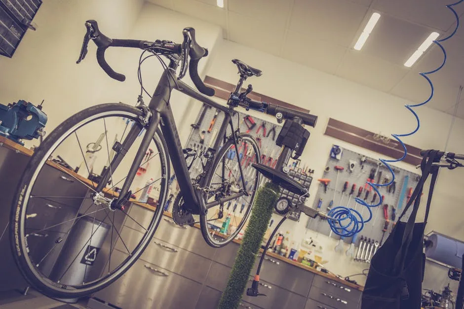 Road bicycle mounted on repair stand inside a busy bike workshop