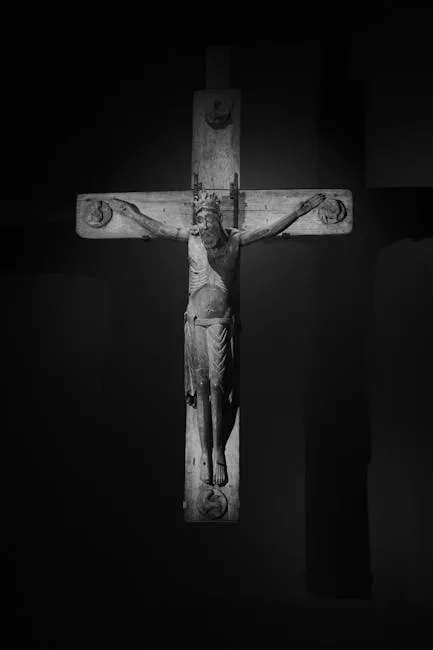 Carved wooden crucifix of Christ illuminated against dark background in Lucca
